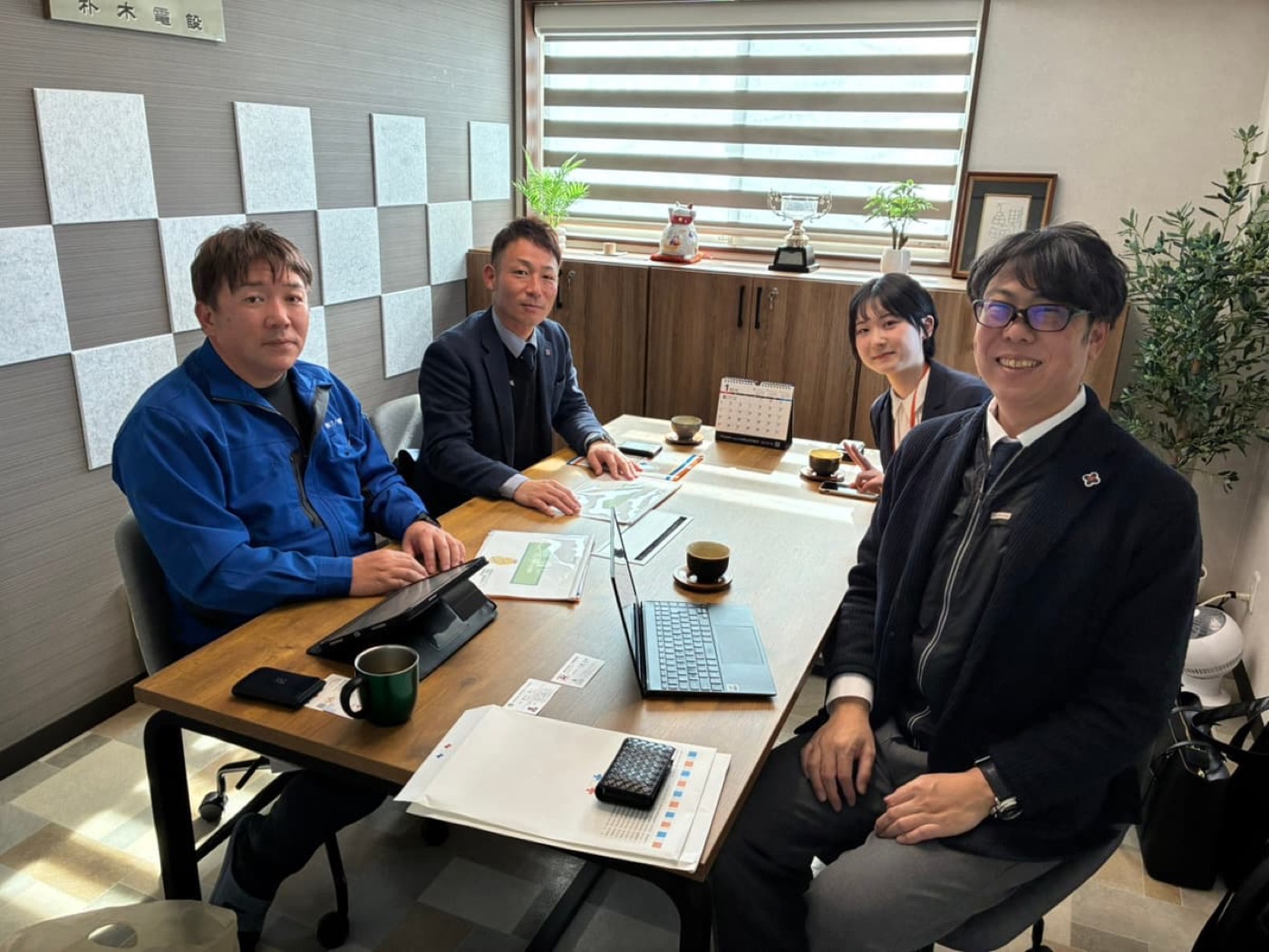訪問先でテーブルを囲み対話する様子