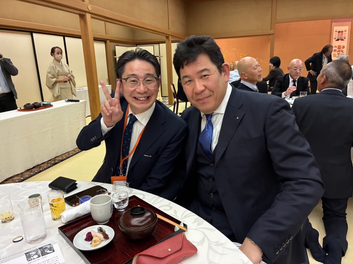 会場で肩を並べて記念撮影する様子