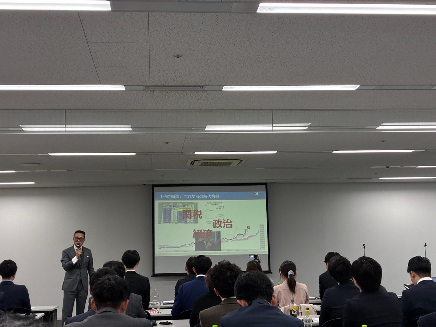 スクリーンを見ながら話を聞く参加者